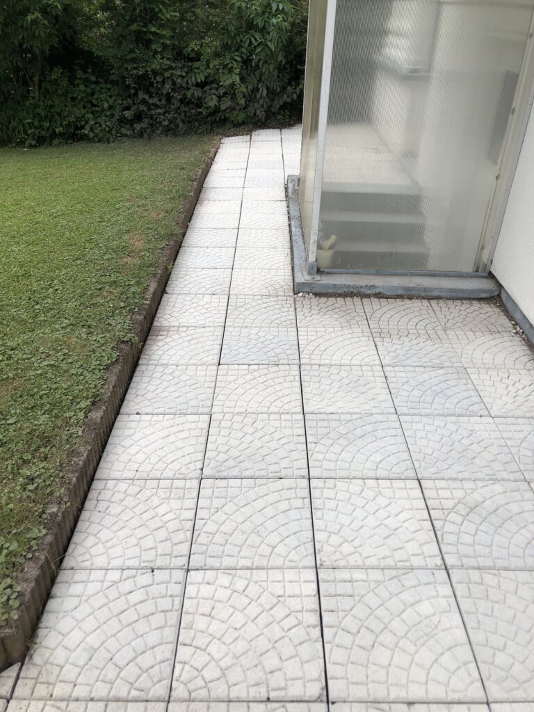 Verwitterter Gartenweg mit Moos, Algen und Umweltschmutz